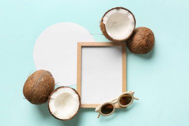 Renkli arkaplanda boş resim çerçevesi, boş kart, hindistan cevizi ve güneş gözlüğü içeren kompozisyon