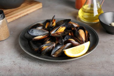 Gri arka planda limonlu lezzetli midyeler.