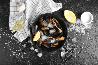 Koyu arkaplanda limonlu ve buzlu lezzetli midyeler.