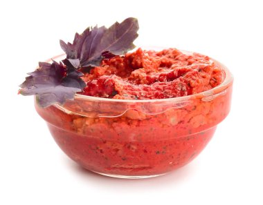 Beyaz arka planda bir kase lezzetli pesto sosu.