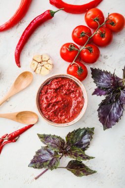 Bir kase lezzetli pesto sosu ve hafif arka planda malzemeler.