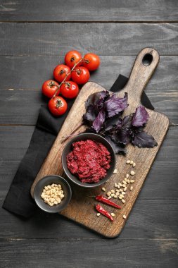 Lezzetli pesto soslu kompozisyon ve koyu ahşap arka planda malzemeler.