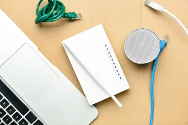 Renkli arkaplanda dizüstü bilgisayar, hoparlör ve kablosuz ağ yönlendirici