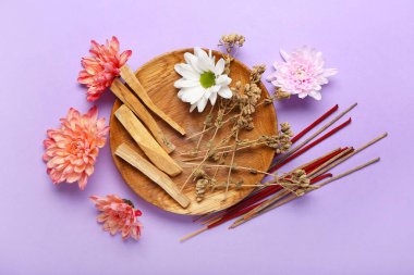Renkli arka planda tütsü, çiçek ve Palo Santo tabağı