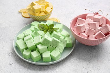 Tabak ve kâselerde hafif arka planda tatlı şekerlemeler.