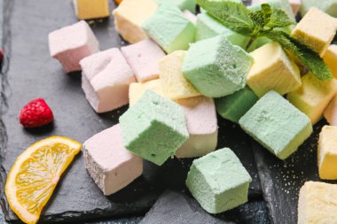 Lezzetli şekerleme, nane ve arkaplanda meyveler.