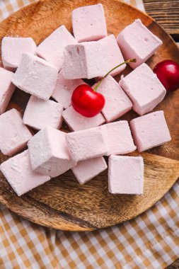 Lezzetli şekerleme tabağı ve ahşap arka planda kirazlar.