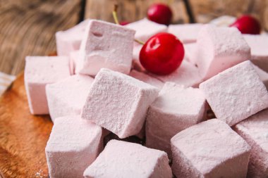 Lezzetli şekerleme tabağı ve ahşap arka planda kirazlar, yakın plan.