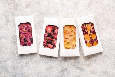 Açık arkaplanda meyve ve böğürtlen bulunan el yapımı çikolatalar.