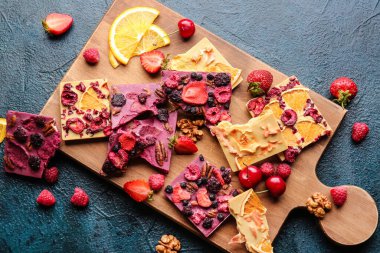 Koyu arkaplanda meyveli ve fındıklı el yapımı çikolatalar.