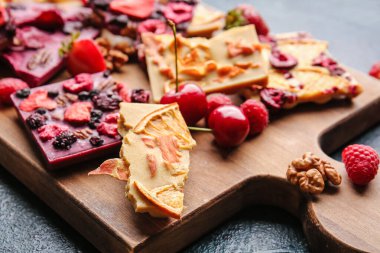 Koyu arkaplanda meyveli ve fındıklı el yapımı çikolatalar.