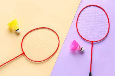 Badminton raketleri ve renkli arka planda mekik horozları