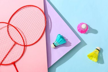 Badminton raketleri ve renkli arka planda mekik horozları