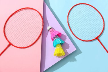 Badminton raketleri ve renkli arka planda mekik horozları