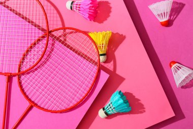 Badminton raketleri ve renkli arka planda mekik horozları