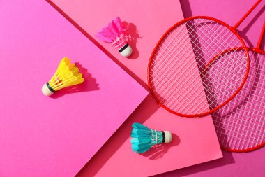 Badminton raketleri ve renkli arka planda mekik horozları