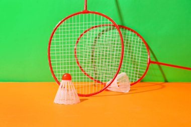 Badminton raketleri ve renkli arka planda mekik horozları