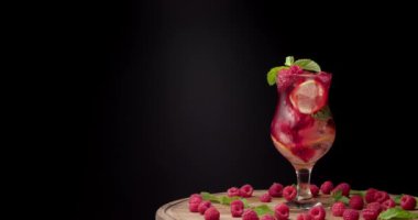 Arka planda bir bardak taze ahududu limonatası.