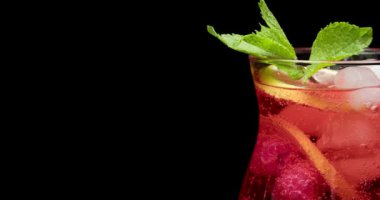 Arka planda bir bardak taze ahududu limonatası, yakın plan.