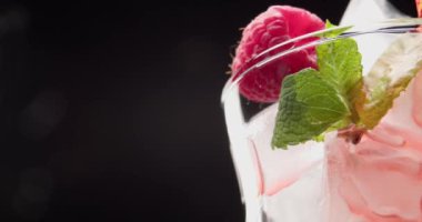 Lezzetli ahududu limonatasını koyu arka planda cama dök, yakın plan