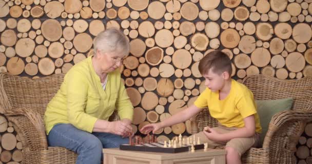 小男孩和他的祖母在家里下棋 — 图库视频影像