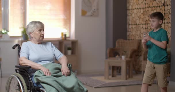 Küçük Çocuk Engelli Büyükannesine Bir Bardak Veriyor — Stok video