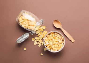 Renkli arkaplanda bir kase lezzetli mısır gevreği ile kompozisyon