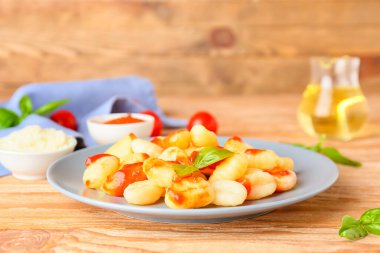 Ahşap masada domates soslu lezzetli gnocchi.