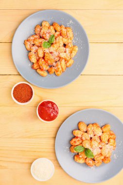 Domates soslu lezzetli gnocchi ve ahşap masa üzerinde tabakta peynir.