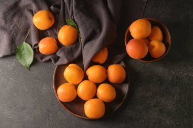 Koyu arkaplanda lezzetli olgun kayısı tabağı.