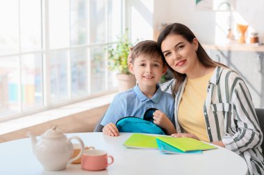 Anne oğlunu okula hazırlıyor.