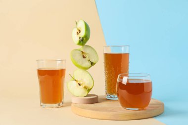 Renkli arkaplanda lezzetli meyve suyu ve elmalar