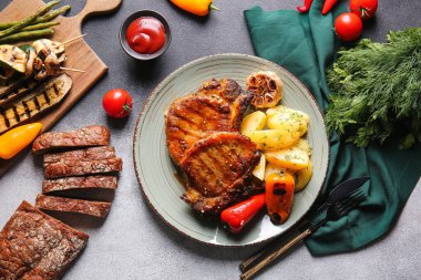 Gri arka planda lezzetli domuz bifteği kompozisyonu