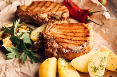 Lezzetli domuz biftekleri ve sebzeler masada, yakın plan.