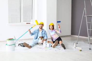 Yeni evlerinde tamirat sırasında şirin köpekleri olan mutlu genç bir çift.