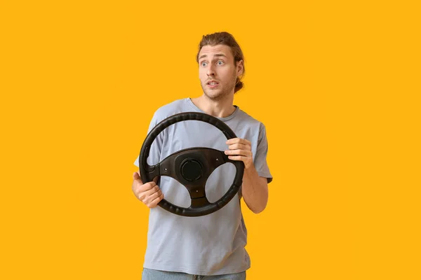 Joven Sorprendido Con Volante Sobre Fondo Color —  Fotos de Stock