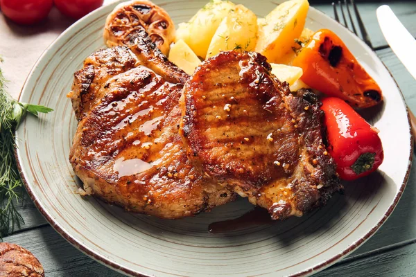 Assiette Avec Savoureux Steaks Porc Légumes Grillés Sur Fond Bois — Photo