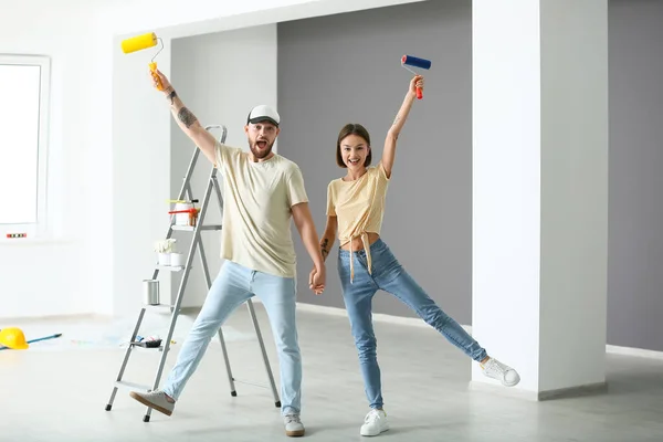 Pareja Joven Con Rodillos Pintura Divirtiéndose Nueva Casa — Foto de Stock