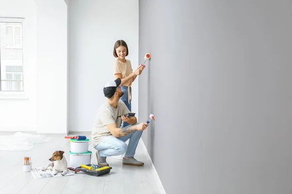 Jovem Casal Com Bonito Cão Pintura Parede Sua Nova Casa — Fotografia de Stock