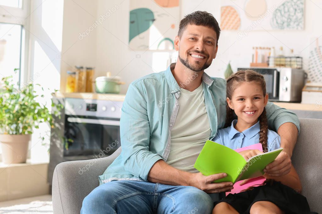 Father and his little daughter with notebook at home