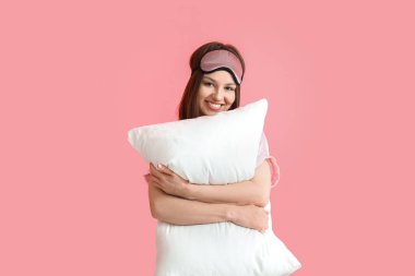 Arka planda yastığa sarılan genç bir kadın