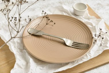 Tahtaya boş tabak ve çatal.