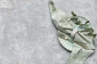 Peçete ve çatalla gri arka planda temiz bir tabak.