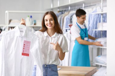 Modern kuru temizlemecide temiz elbiseli bir müşteri.