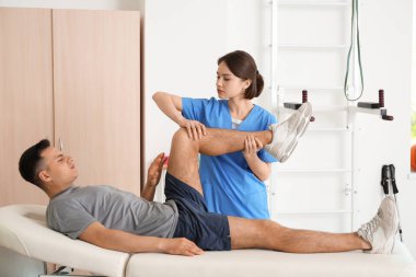 Rehabilitasyon merkezinde hastayla çalışan fizyoterapist.