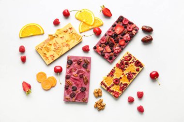 Beyaz arka planda meyveli, meyveli ve fındıklı el yapımı çikolatalar.