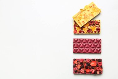 Beyaz arka planda meyveli, meyveli ve fındıklı el yapımı çikolatalar.