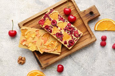 Açık arkaplanda meyve ve böğürtlen bulunan el yapımı çikolatalar.