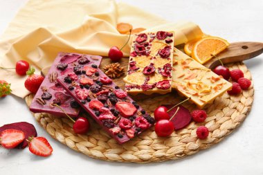 Beyaz arka planda meyveli, meyveli ve fındıklı el yapımı çikolatalar.