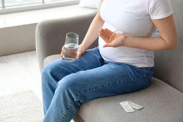年轻的孕妇 家里有药丸和水 — 图库照片
